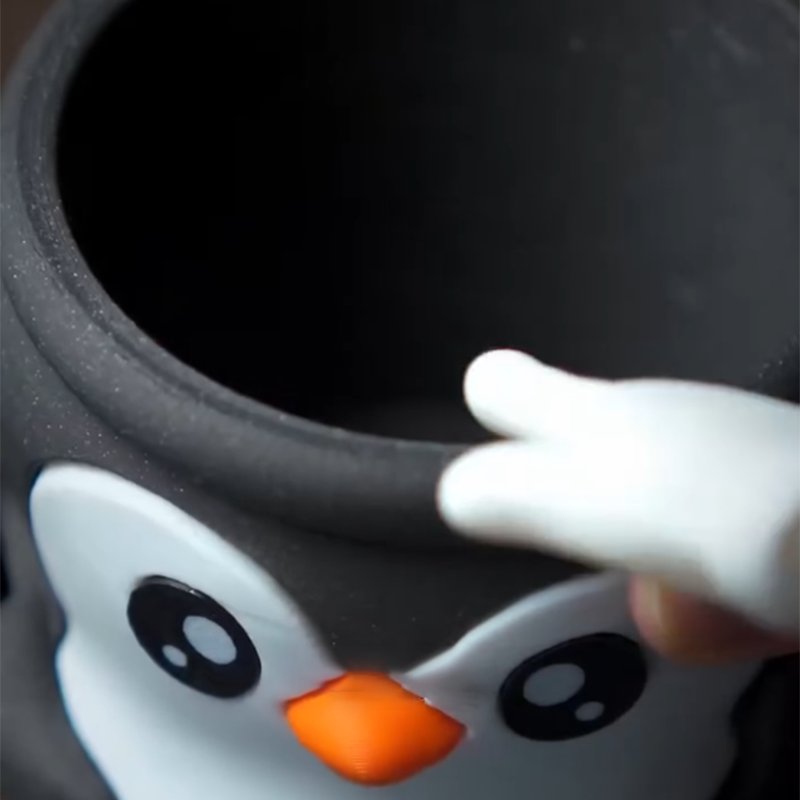Söpö pingviini jäätelöpikarin pidike